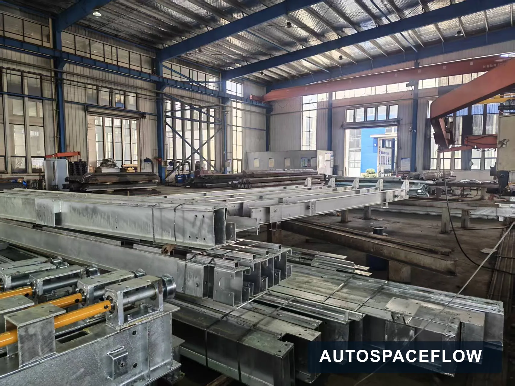 Parking system steel beams and drive assemblies staged during production at the AutoSpaceFlow factory