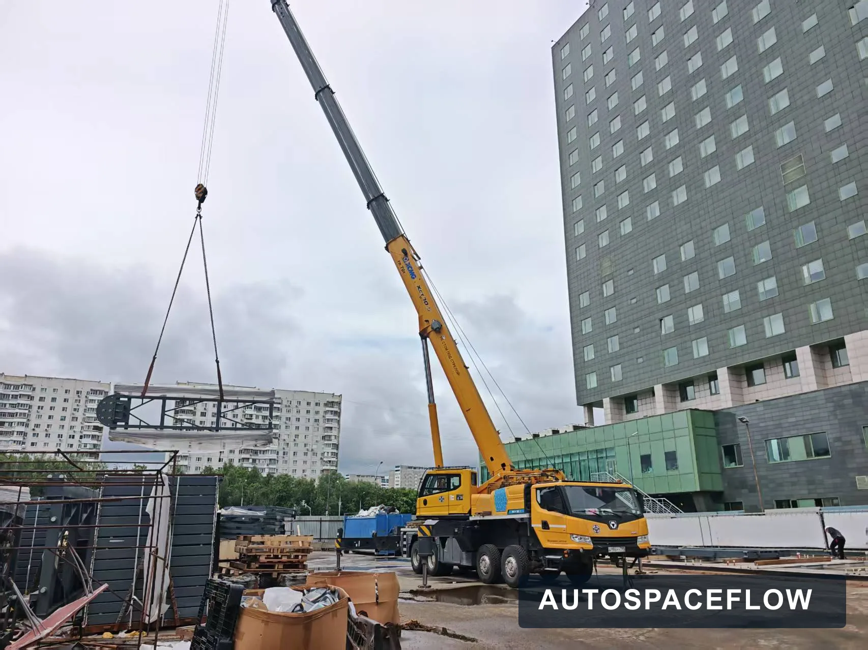 Moscow automated parking installation site with mobile crane lifting steel platform modules
